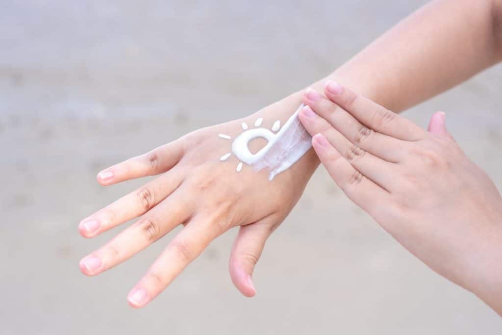 Les femmes asiatiques appliquent la protection solaire sur les mains et les bras 