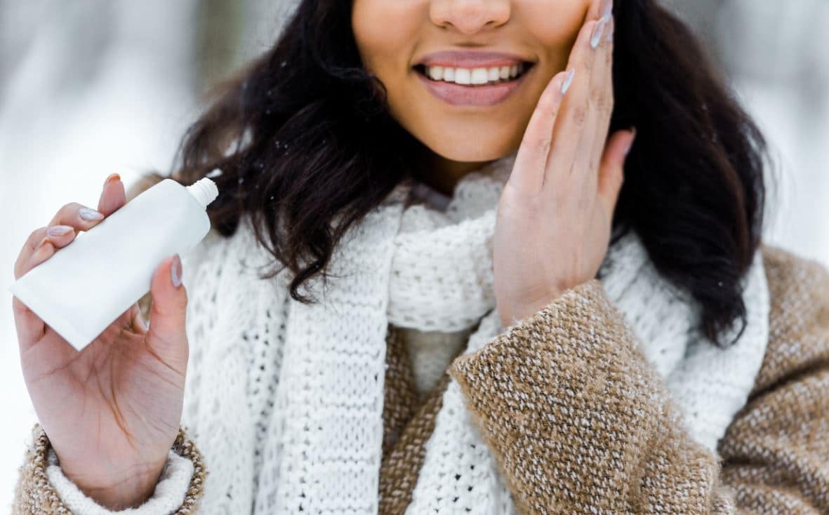 Femme S'appliquant De La Creme En Hiver