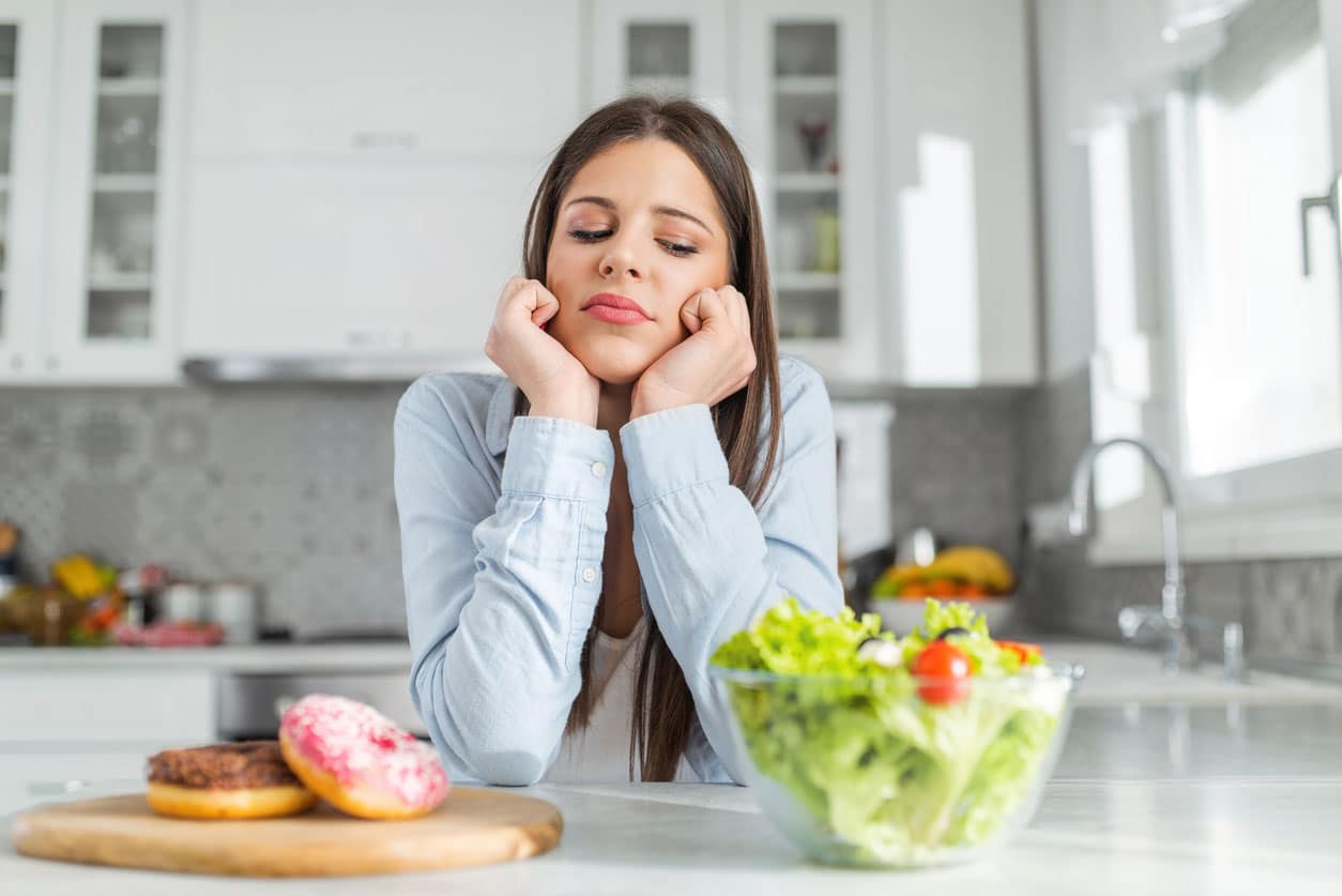 femme qui se sent mal devant de la nourriture