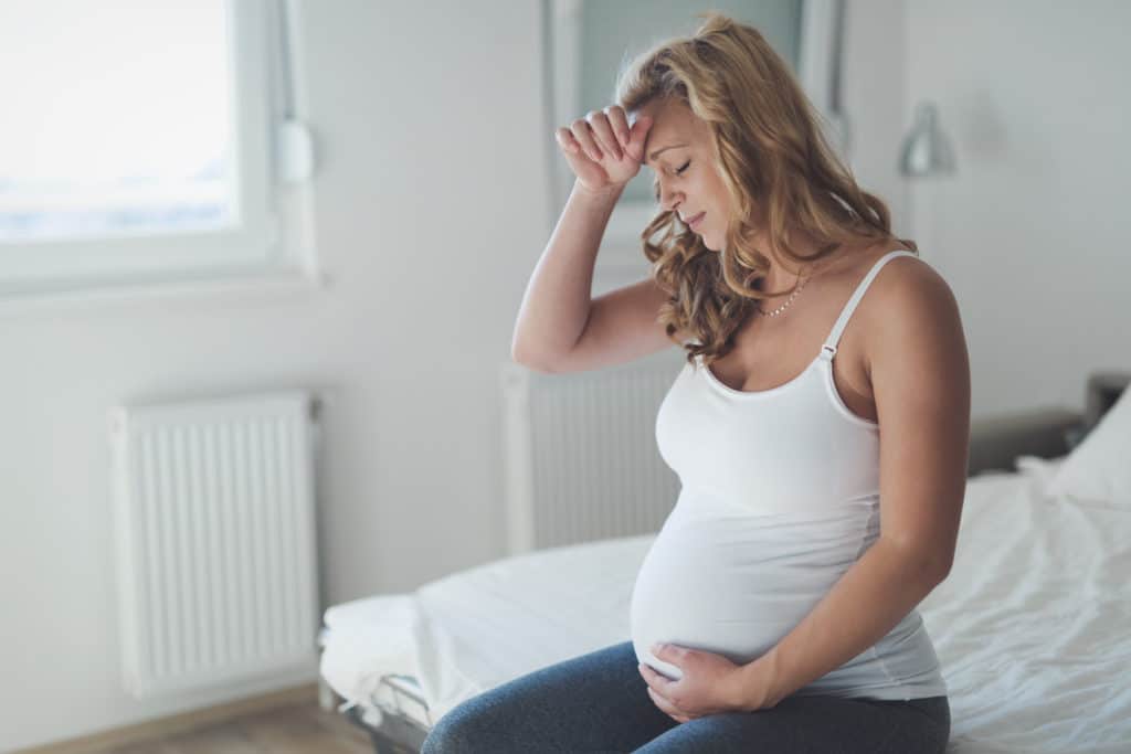 femme enceinte inquiete sur son lit 
