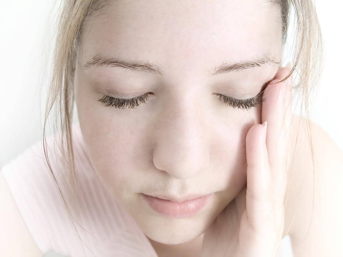 femme qui s'applique un eclaircissant sur le visage