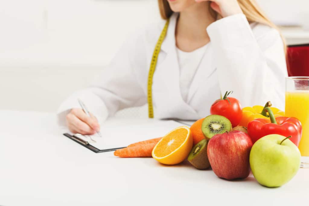 Bureau de nutritionniste avec fruits et ruban à mesurer