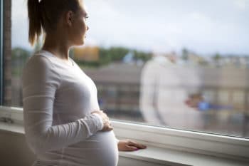 femme enceinte heureuse, regardant par la fenêtre