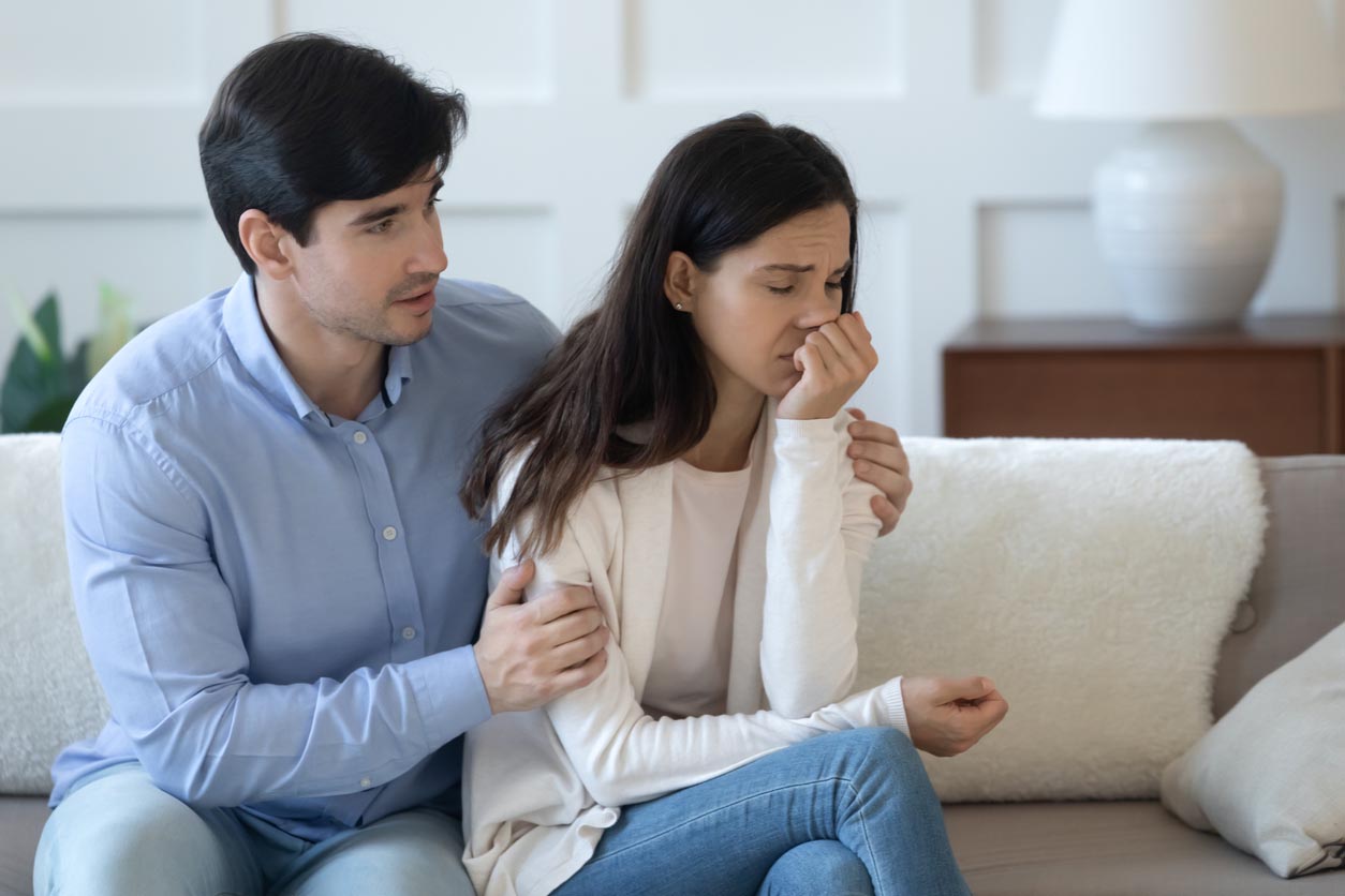 Jeune homme affectueux bienveillant embrassant la jeune femme stressée