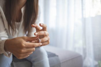 Femme malheureuse retirant sa bague de mariage