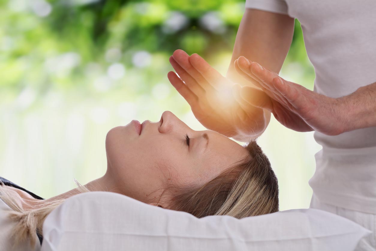 Homme pratique le Reiki sur une femme