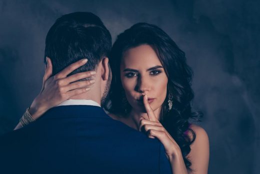 Femme brune fait un calin à un homme en faisant chut