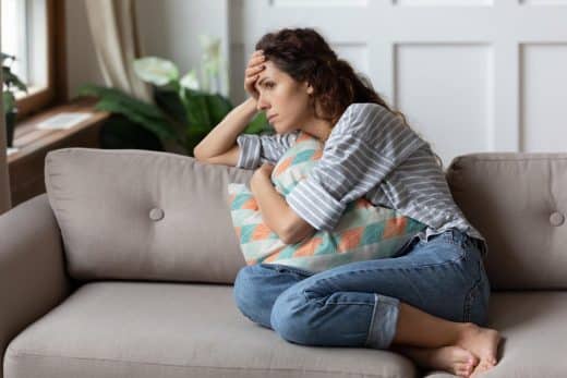 femme pensive et seule sur son canapé