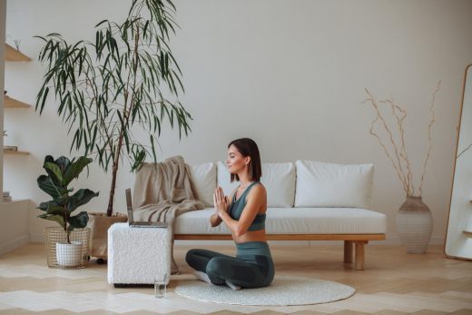 Une jeune femme pratique la méditation à la maison en survêtement