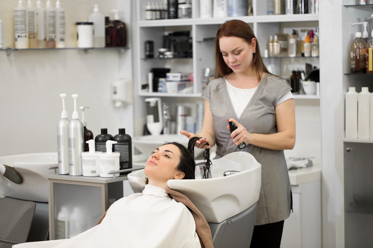 Une femme fait un shampoing chez le coiffeur