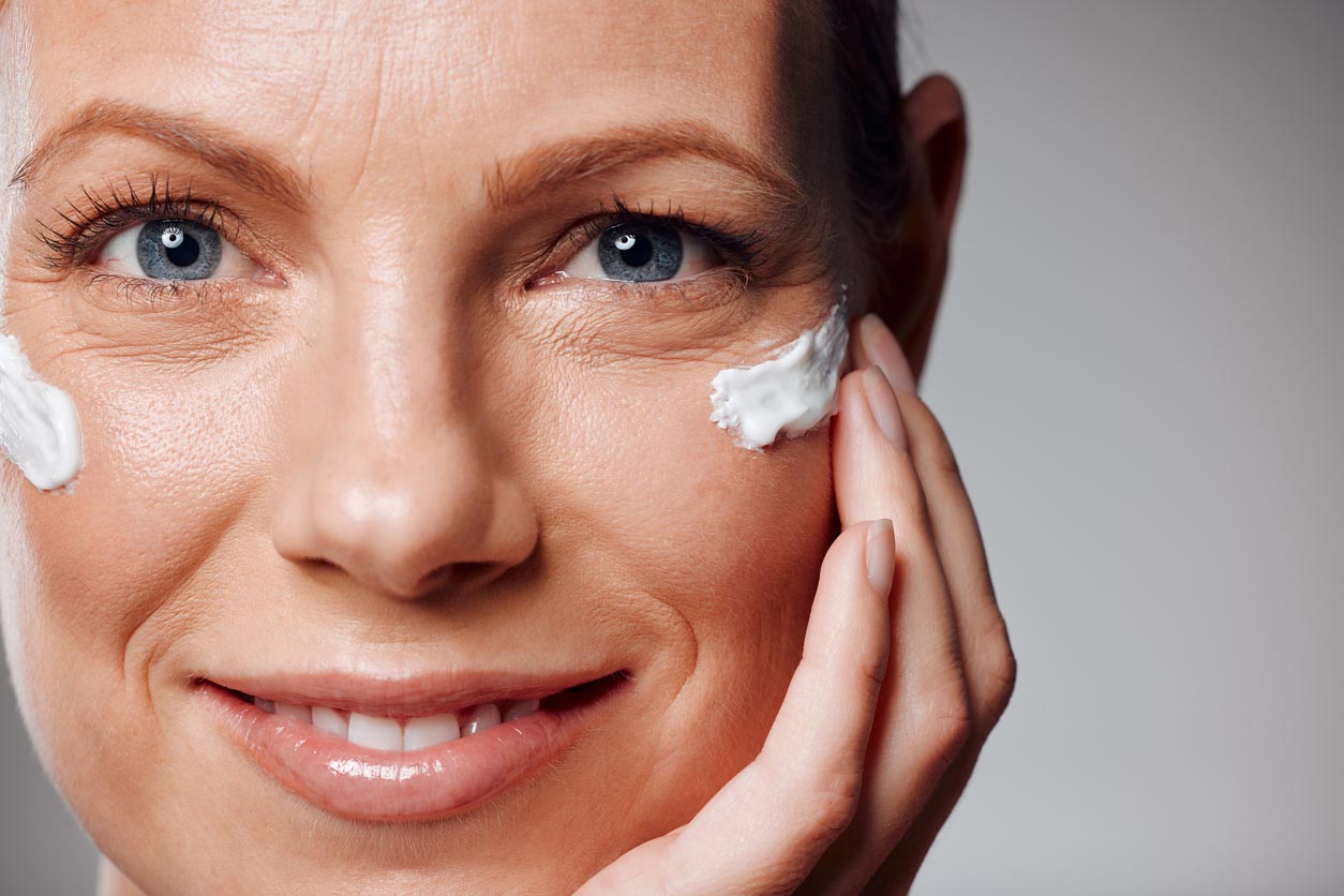 Femme avec de la crème antirides sur le visage