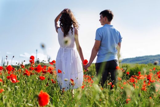 Jeune couple heureux sur une prairie de coquelicots