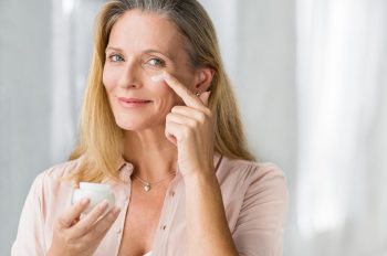 Femme meture met de la crème sur son visage