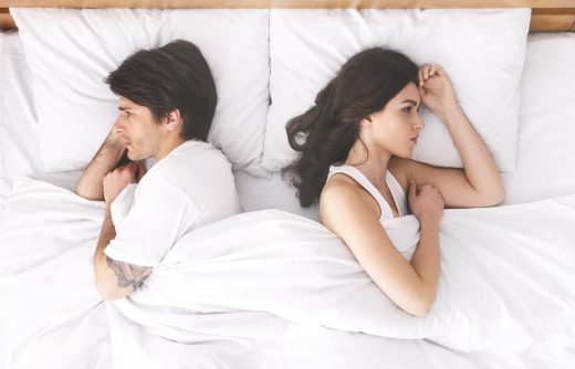 Couples bouleversés ignorant l'un l'autre, se couchant dos à dos dans le lit