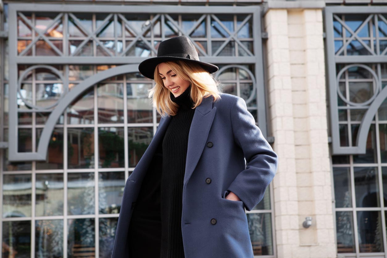 Femme fait un shooting photo dans la rue avec manteau et chapeau