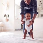 Papa guidant sa petite fille pour faire ses premiers pas