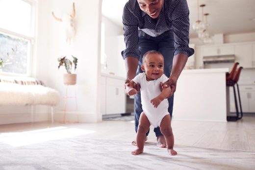 Papa guidant sa petite fille pour faire ses premiers pas