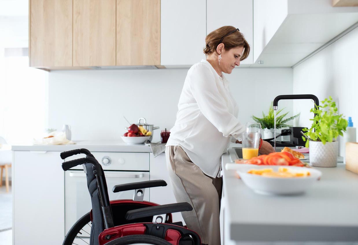 femme adulte handicapée avec fauteuil roulant à l’intérieur à la maison