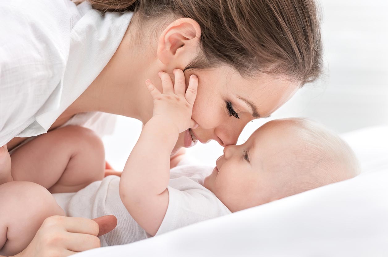 Une mere et son bébé font un calin