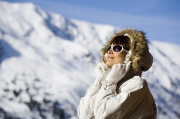 Femme sur une terrasse dans les montagnes enneigées