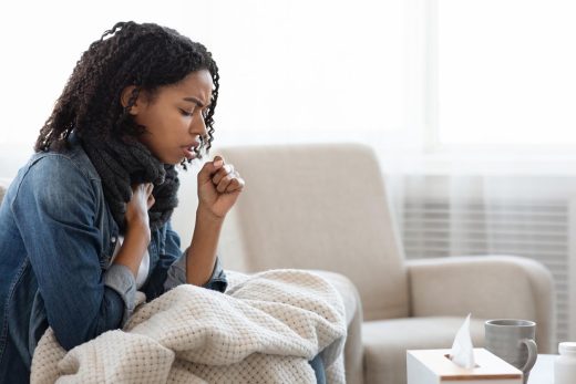 Femme tousse sur son canapé