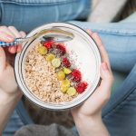 Femme Qui Mange Un Bol D'avoine Et De Fruits