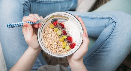 Femme Qui Mange Un Bol D'avoine Et De Fruits