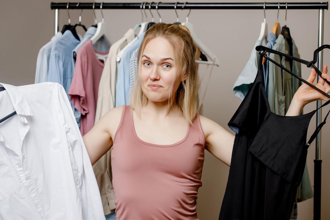 femme hésitant entre deux vêtements de style différents