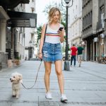 femme se promène avec son chien en laisse en ville