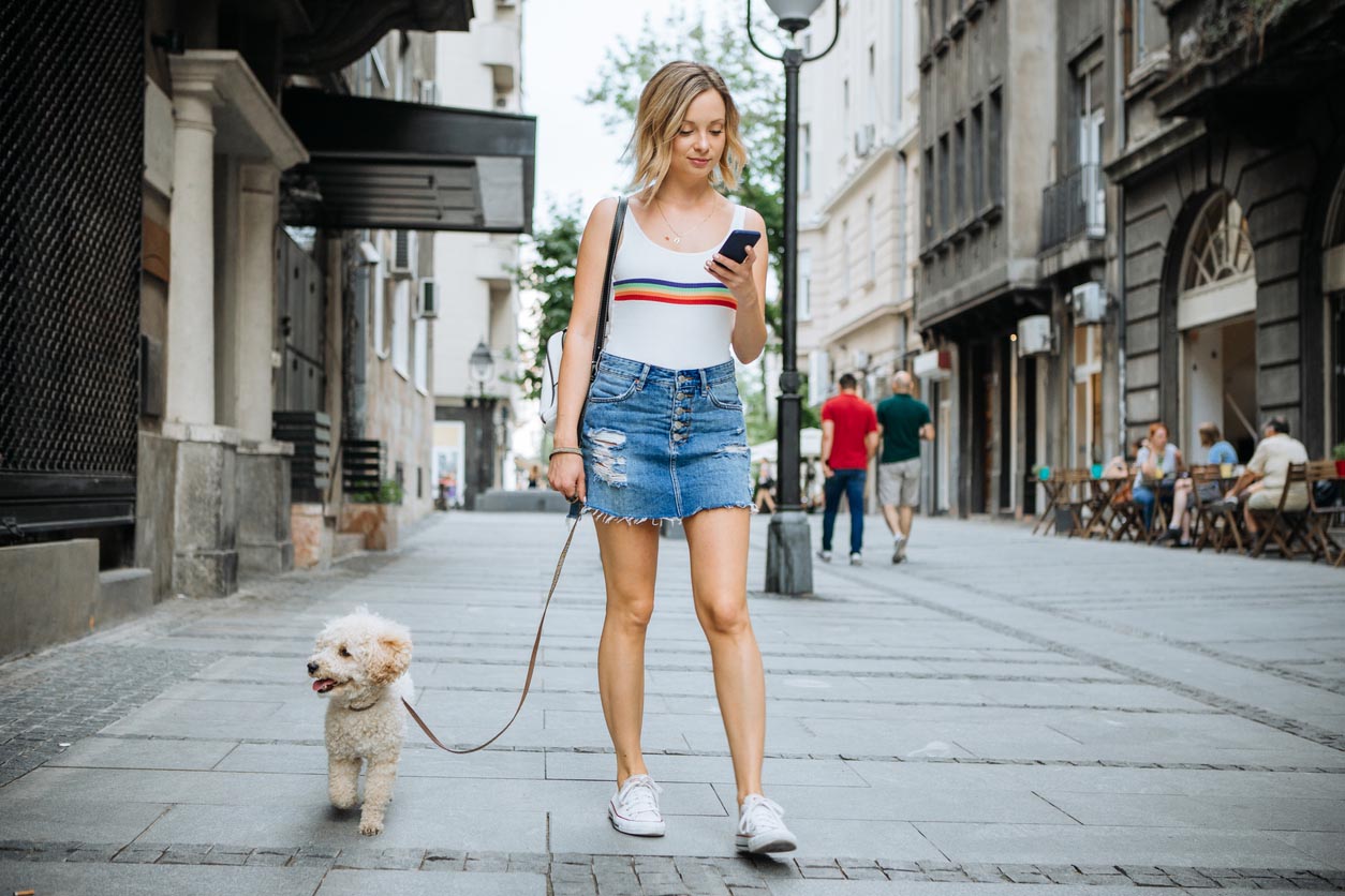 femme se promène avec son chien en laisse en ville