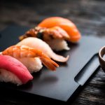 Sushis Dégustés Avec Des Baguettes Et Petite Sauce Qui Accompagne