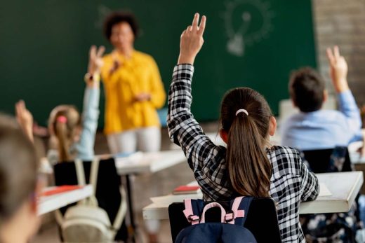 élèves lèvent la main en classe