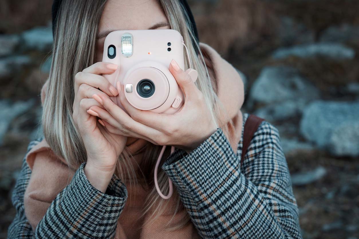 femme prend un photo avec un instax mini