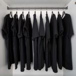 armoire remplie de vêtement noir sur cintres