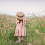 Petite fille dans une belle robe dans un champ fleuri un jour d’été