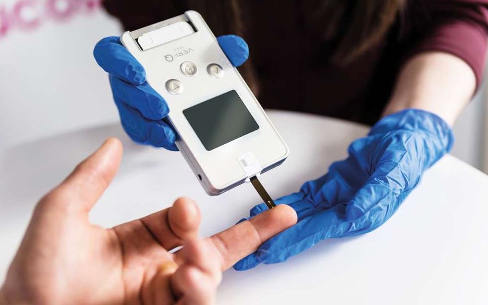 Test à L'aide Lecteur De Cholestérol Pique Le Doigt