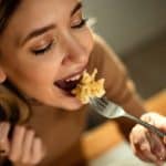 Femme Heureuse Qui Mange