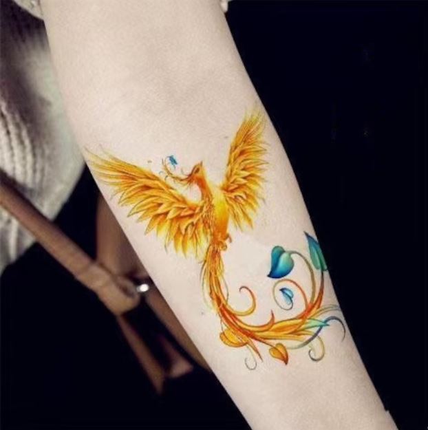 Tatouage Phœnix Jaune Avec Des Touches Bleues Sur L’avant Bras