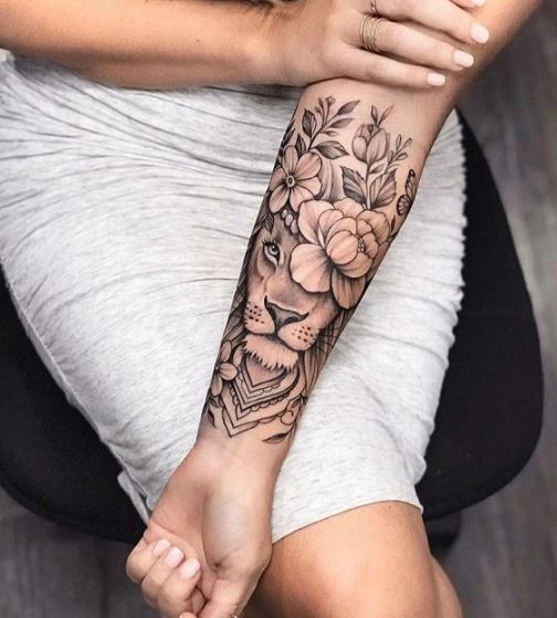 Tatouage Lion Avec Couronne De Fleurs Sur L’avant Bras