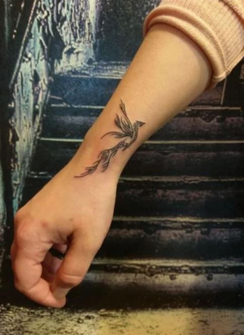 Tatouage Phœnix Noir Discret En Plein Envol Sur Le Poignet
