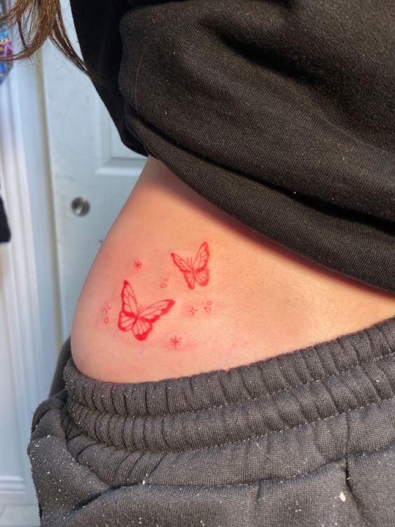 Tatouage Papillon Et étoiles Rouges Sur La Hanche