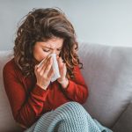 femme se mouchant sur son canapé