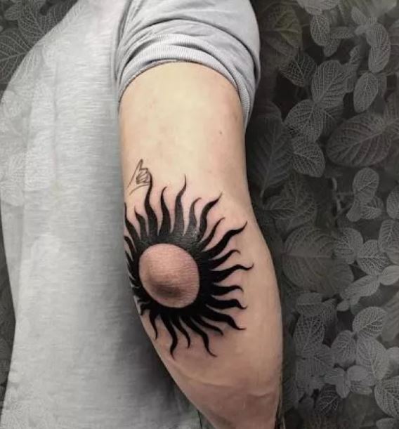 Tatouage Soleil Avec Rayons Ondulés à L'encre Noire Sur Le Coude