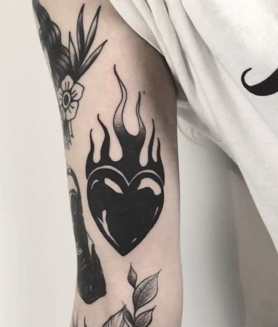 Tatouage Coeur Et Flammes Noirs Sur Le Bras