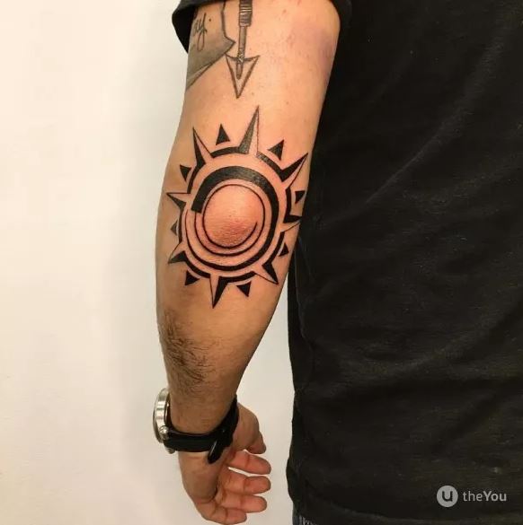 Tatouage Soleil Tribal Avec Rayons En Pointe De Lance Sur Le Coude