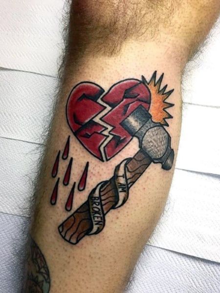 Tatouage Coeur Brisé Par Un Marteau Sur La Jambe