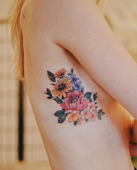 Tatouage Pivoine Rouge Et Fleurs Jaune Et Bleu Sur Les Côtes