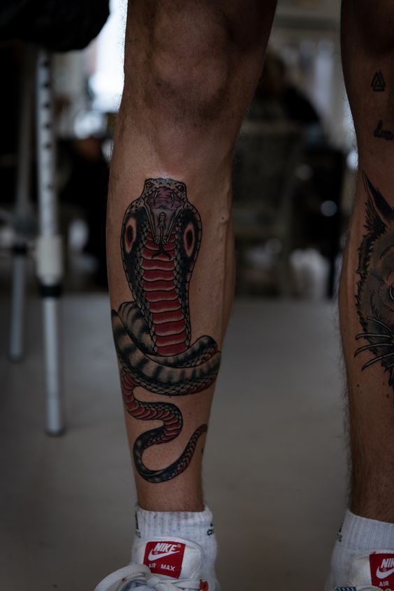 Tatouage Cobra Noir Et Rouge Sur La Jambe