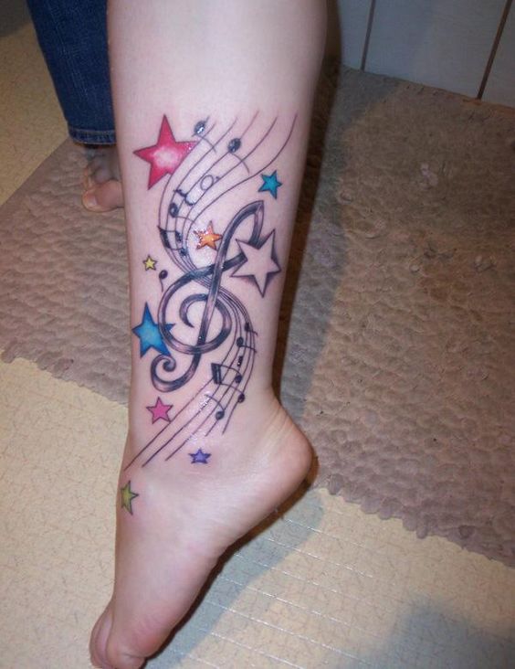 Tatouage étoiles Multicolores Et Notes De Musique Sur La Jambe