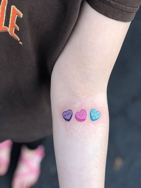 Tatouage Trois Coeurs Colorés Avec Mots Et Initiales Sur L'avant Bras